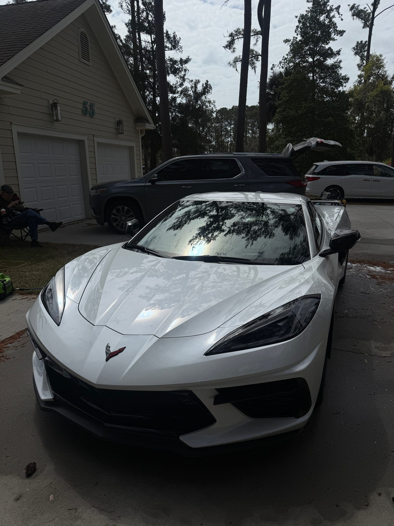 White Chevrolet Corvette parked in a driveway with a garage